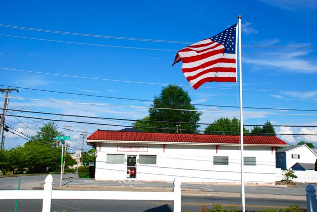 American Flag Flying High Over Elm Street